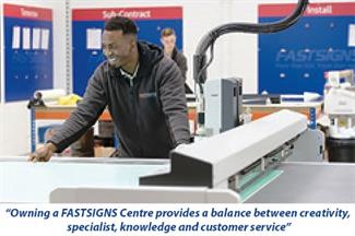 FASTSIGNS Centre worker on a printer